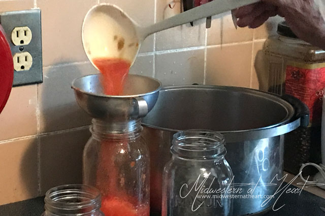 Midwestern at Heart: Placing tomatoes into a jar via a jar funnel.